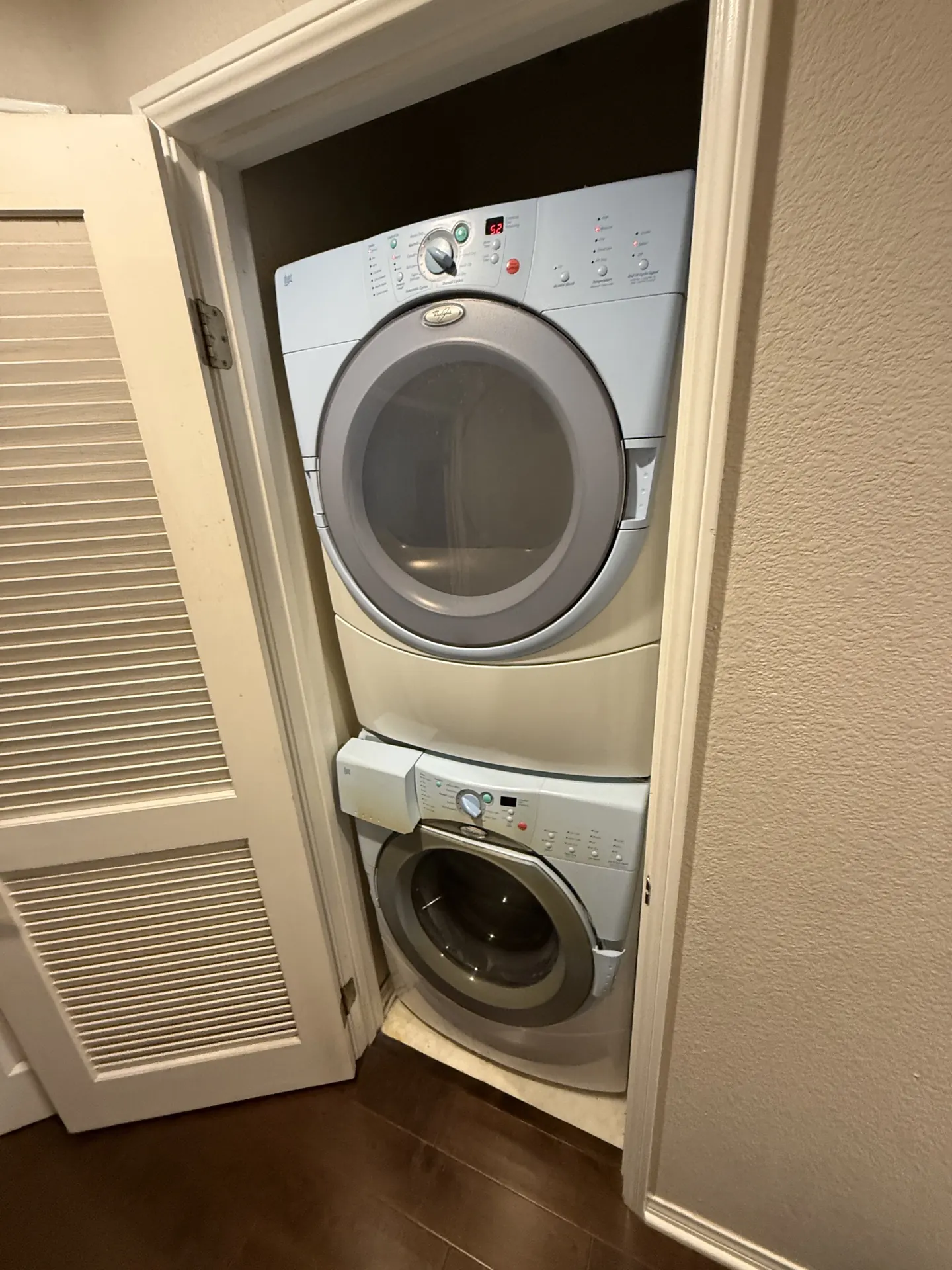 A front-load dryer stacked in a closet