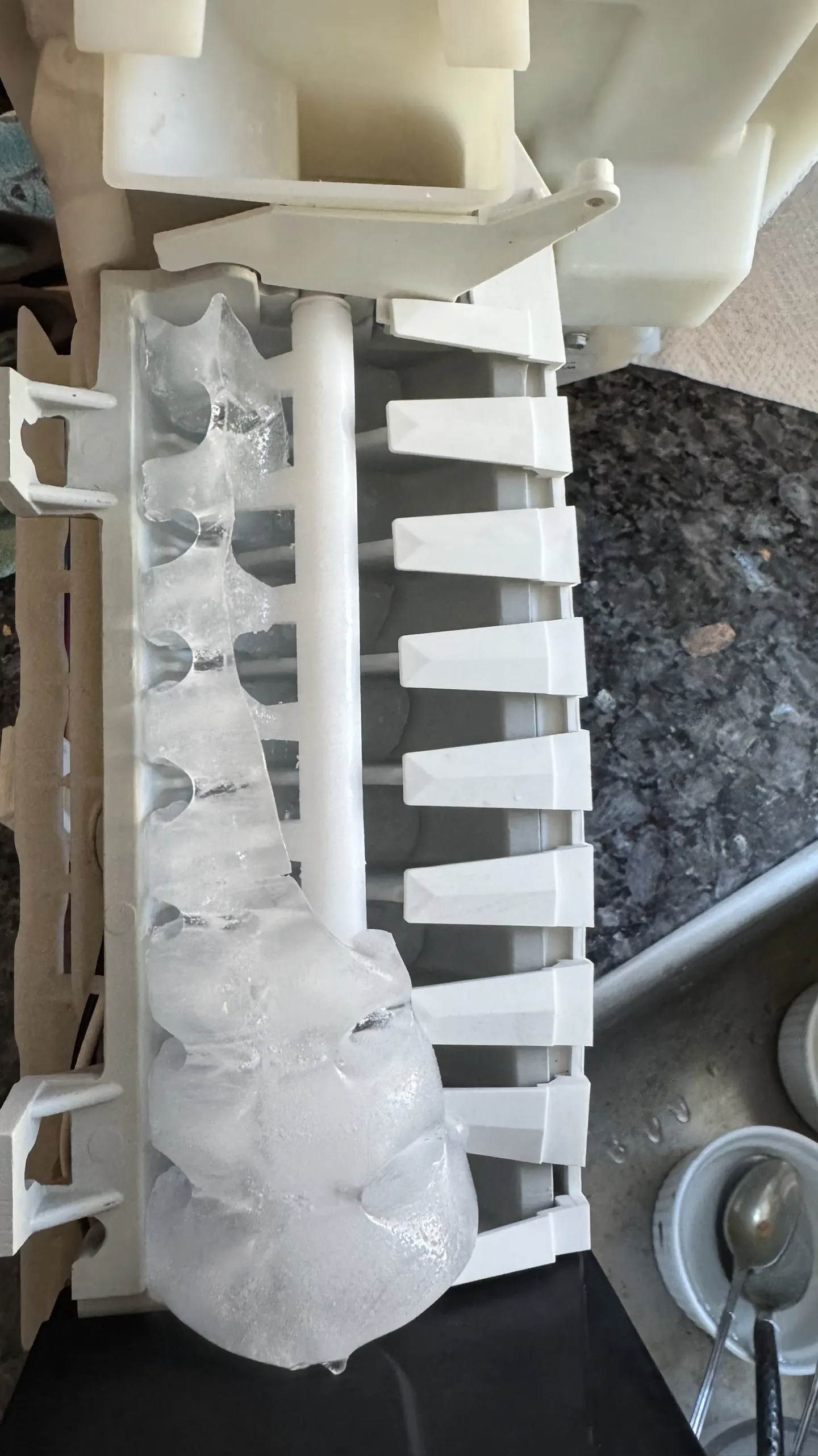 An ice maker frozen solid before the repair