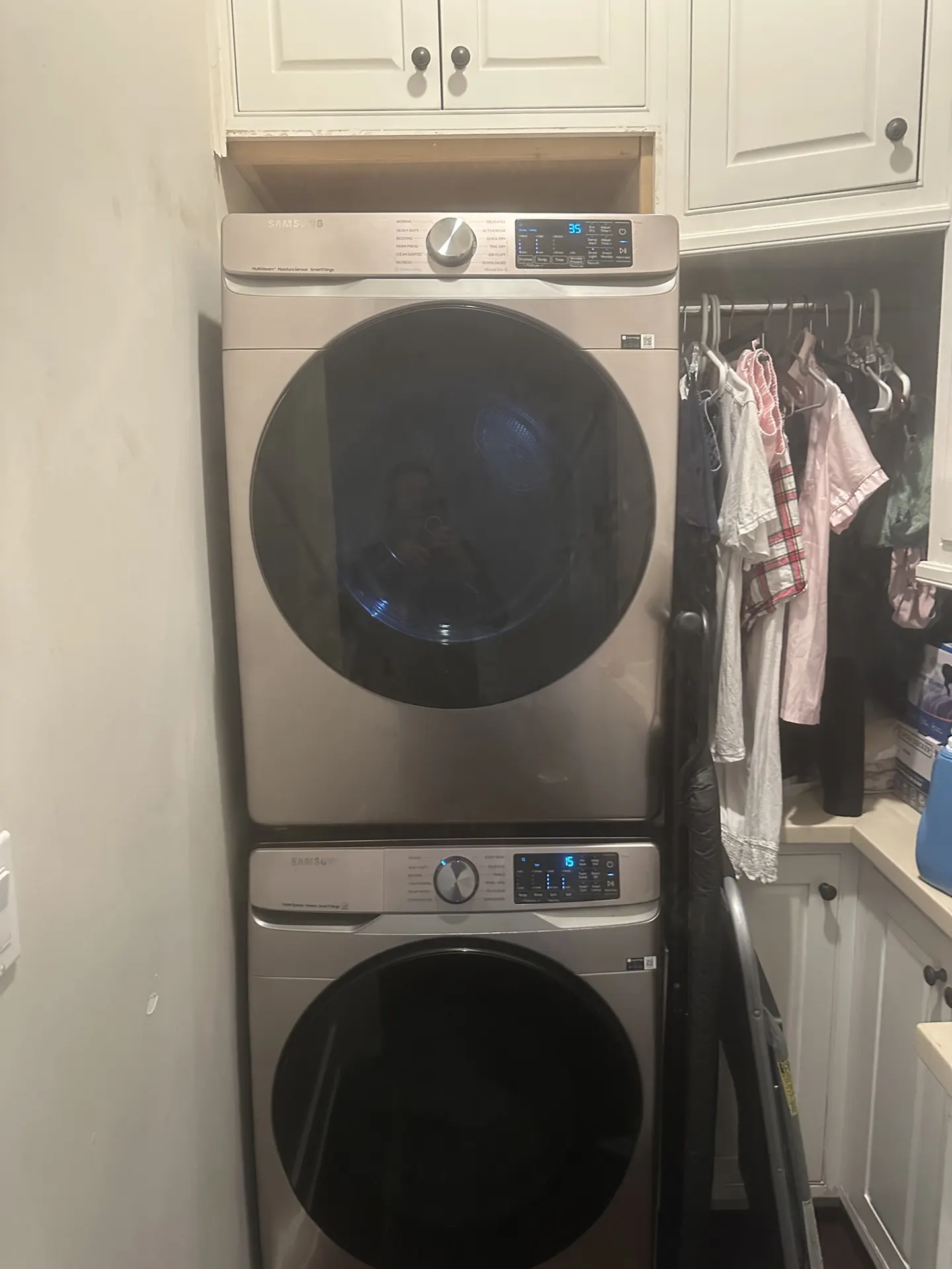 A stacked Samsung washer and dryer in a laundry nook