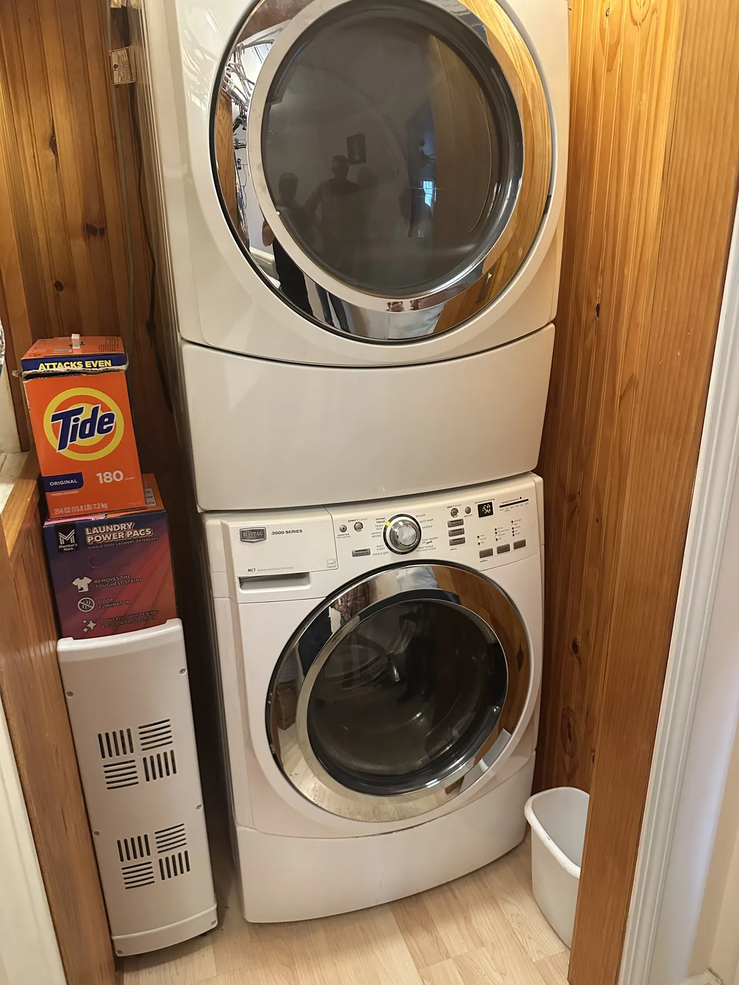 A stacked washer and dryer in a hallway closet